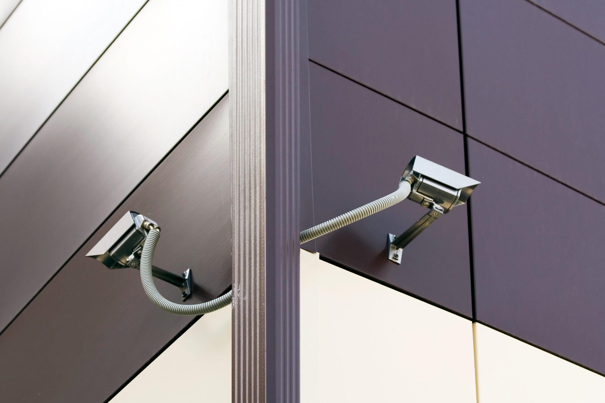 Two CCTV Security Cameras at a corner of office building.